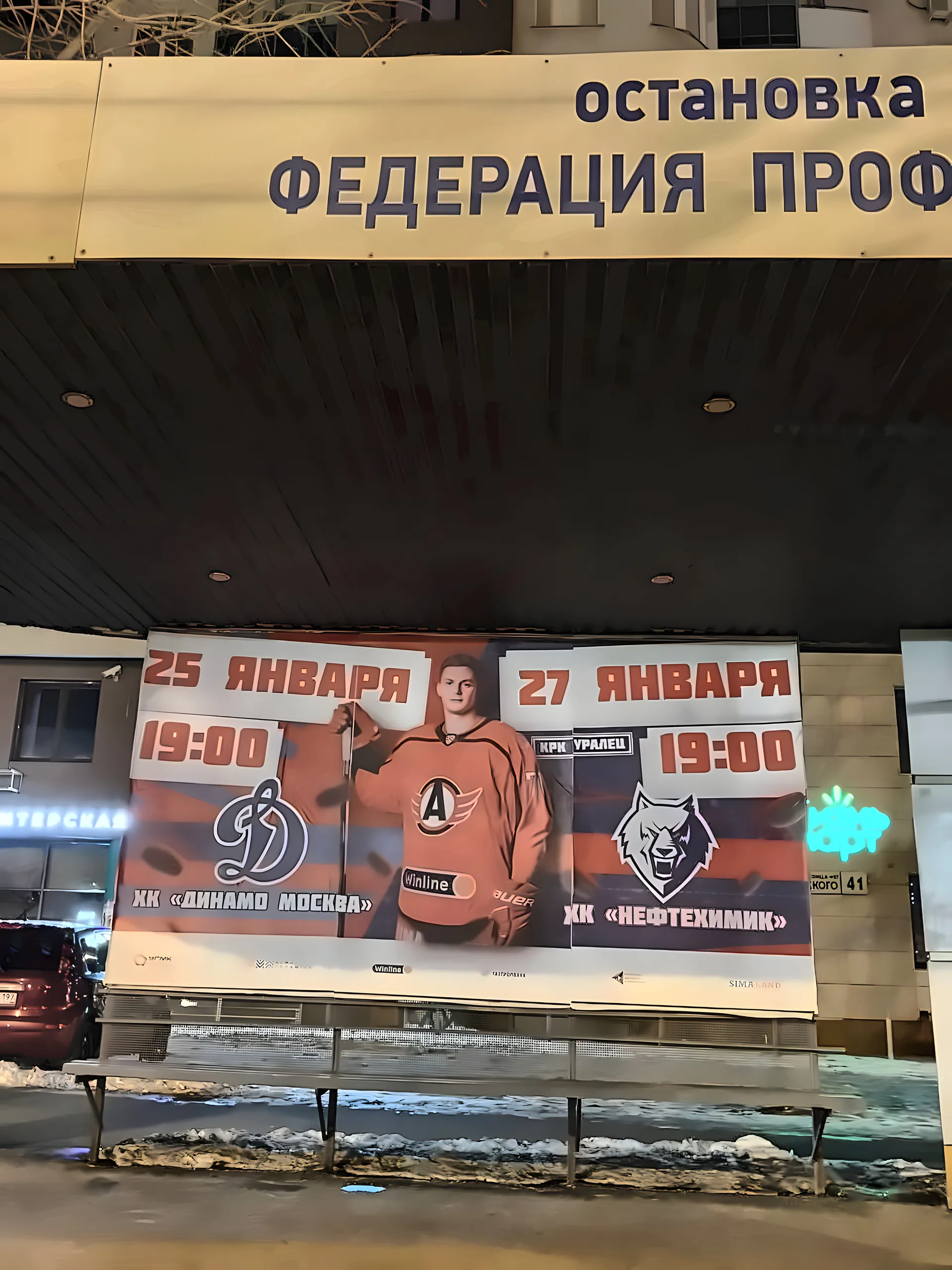 Hockey game billboard on a transit stop at night