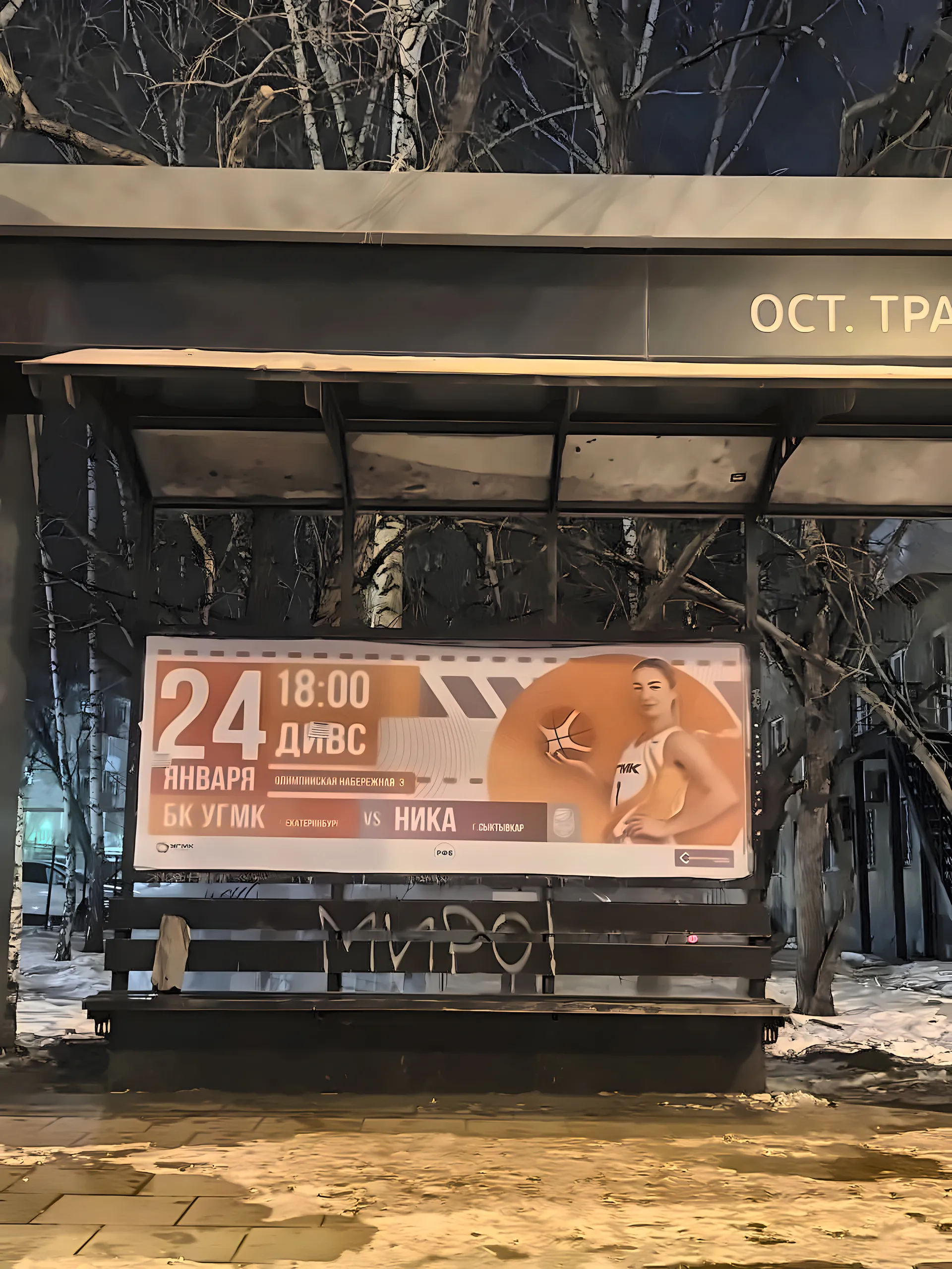 Basketball game billboard on a transit stop at night